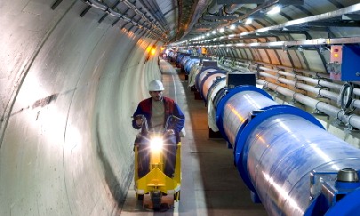 Ein Abschnitt des LHC-Tunnels mit supraleitenden Magnetrohren, die bis zu 8 Tesla erreichen. Diese hohen Feldstärken sind nötig, um künftig zwei Protonenstrahlen bei knapp 300 000 Kilometer je Sekunde in eine Kreisbahn zu zwingen. Abb.: CERN