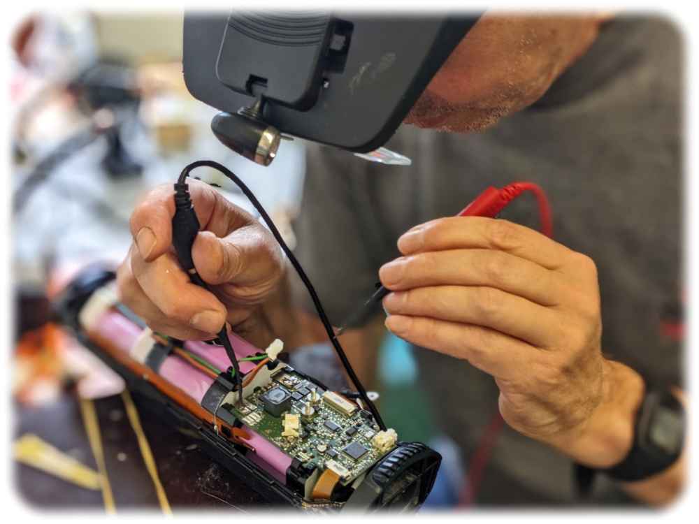 Ein Liofit-Mitarbeiter repariert defekte Elektronik an einem Akku. Foto: Liofit
