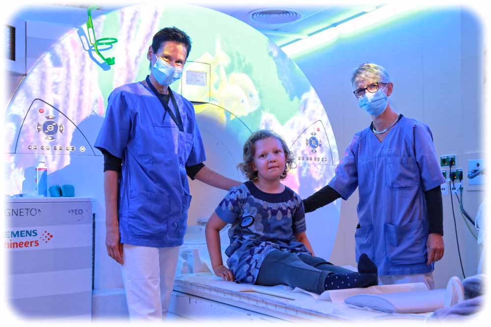 Die siebenjährige Lotta testet mit den Radiologieassistentinnen Daniela Ludwig (l.) und Emöke Böhme die Themenwelt "Ozean" im MRT-Raum. Foto: Ines Mallek-Klein für die Hochschulmedizin Dresden