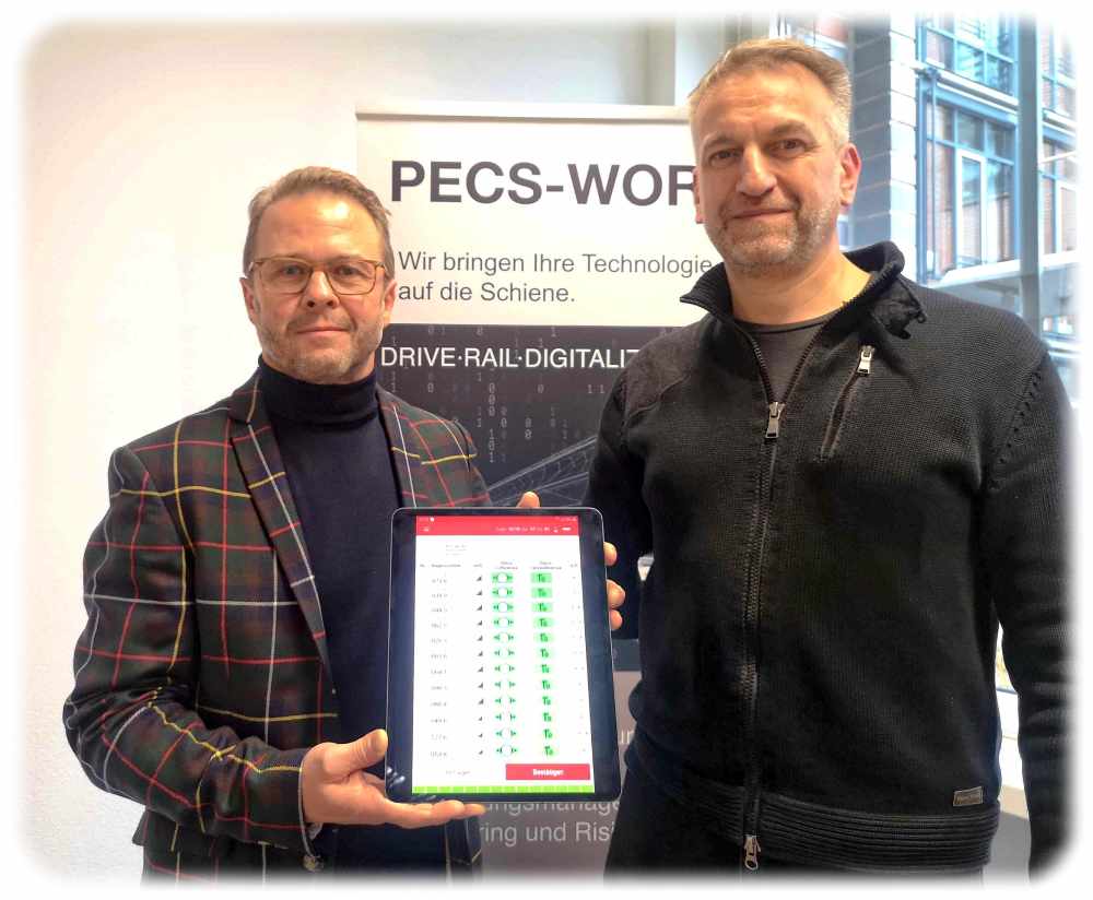 Die Pecs-Work-Chefs Ingolf Sauermann (links) und Karsten Jähnigen zeigen auf einem Tablettrechner, wie das System die automatische Bremsprobe für die Mitarbeiter der Schweizer SBB Cargo visualisiert. Foto: Heiko Weckbrodt